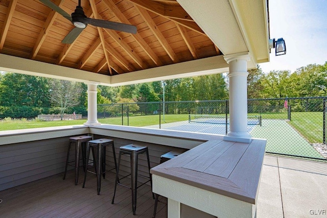 view of patio featuring tennis court, ceiling fan, and an outdoor bar