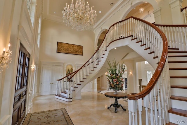 entryway featuring a high ceiling, an inviting chandelier, and crown molding