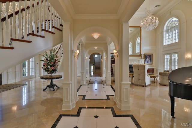 interior space with french doors, a towering ceiling, an inviting chandelier, and ornamental molding