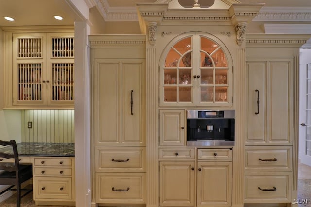 interior space with cream cabinetry, built in desk, and crown molding