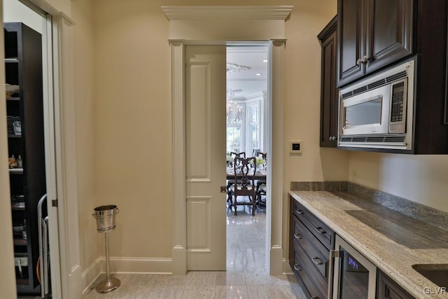 interior space with dark brown cabinetry, light stone countertops, and stainless steel microwave