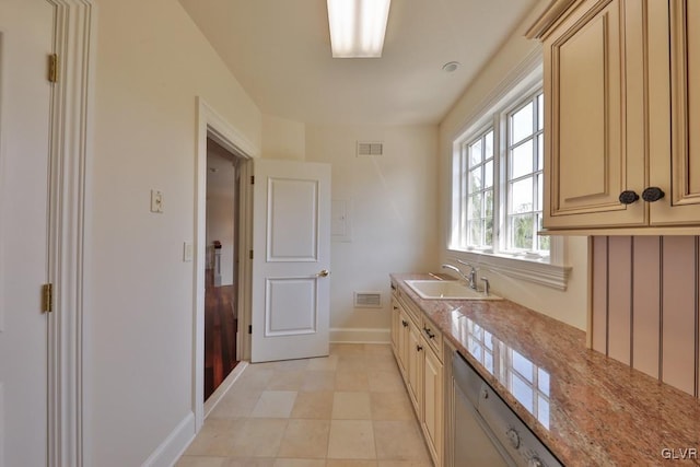 kitchen with dishwasher, light stone counters, and sink