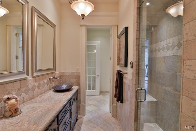 bathroom with tile patterned flooring, vanity, an enclosed shower, and crown molding