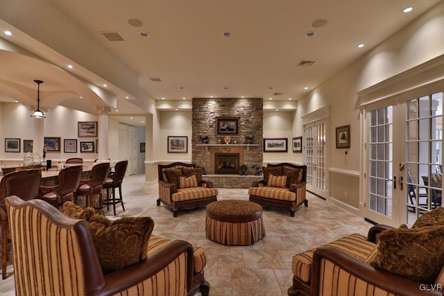 living room featuring indoor bar, a fireplace, and french doors