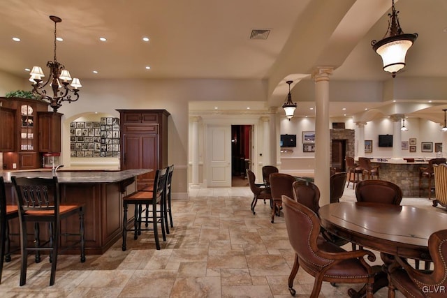 dining room with ornate columns and an inviting chandelier