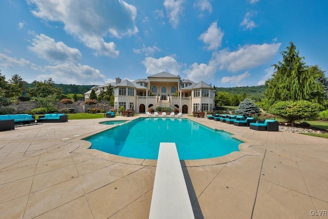 view of swimming pool featuring an outdoor living space, a diving board, and a patio area