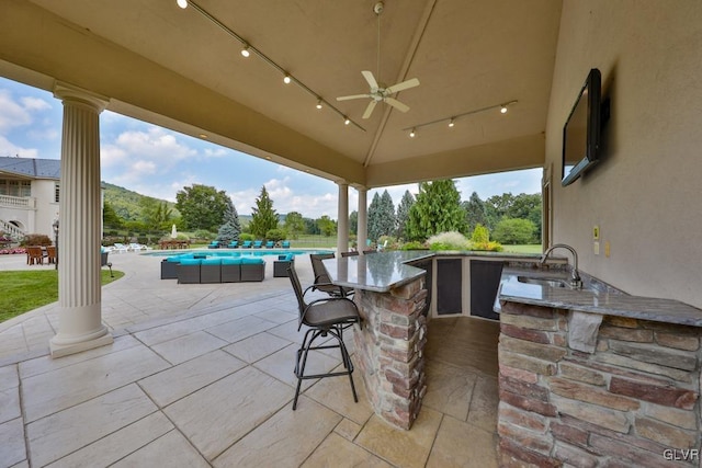 view of patio featuring ceiling fan and an outdoor wet bar