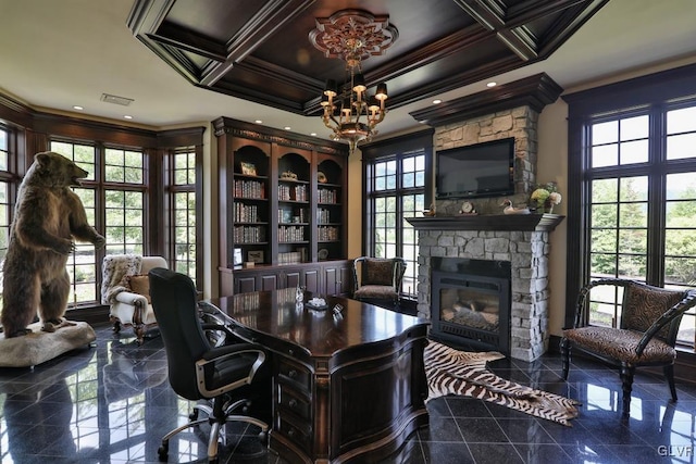 office space with coffered ceiling, a stone fireplace, ornamental molding, and an inviting chandelier