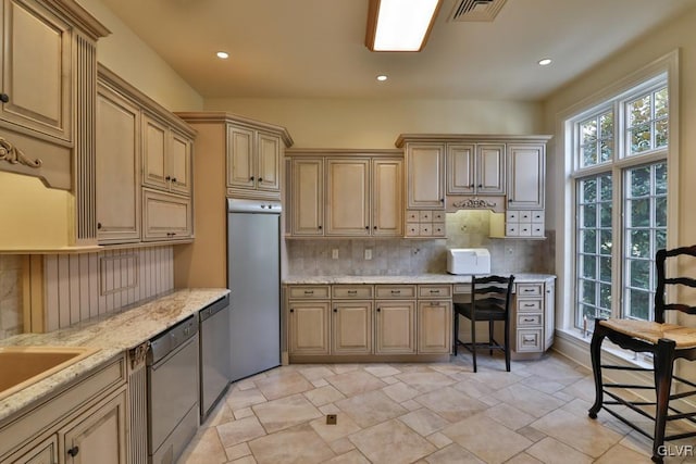 kitchen with tasteful backsplash, light stone countertops, a breakfast bar, and stainless steel appliances