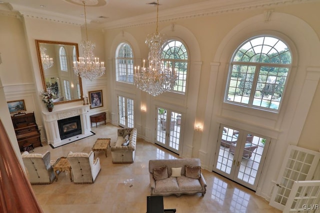 living room with crown molding, french doors, a towering ceiling, and a healthy amount of sunlight