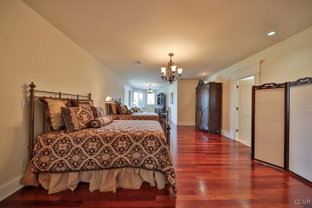 bedroom with a chandelier and wood-type flooring