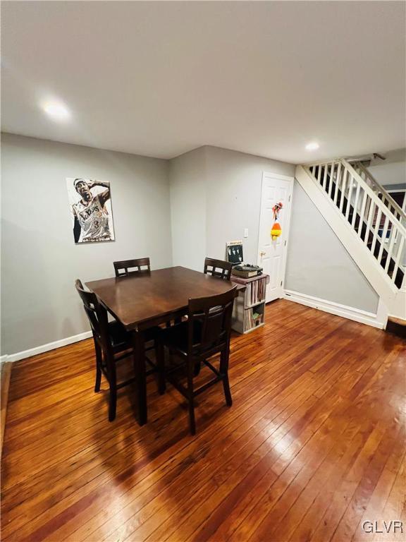 dining area featuring stairs, wood finished floors, and baseboards