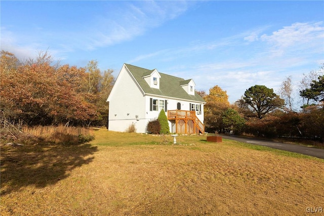 view of property exterior featuring a deck and a lawn