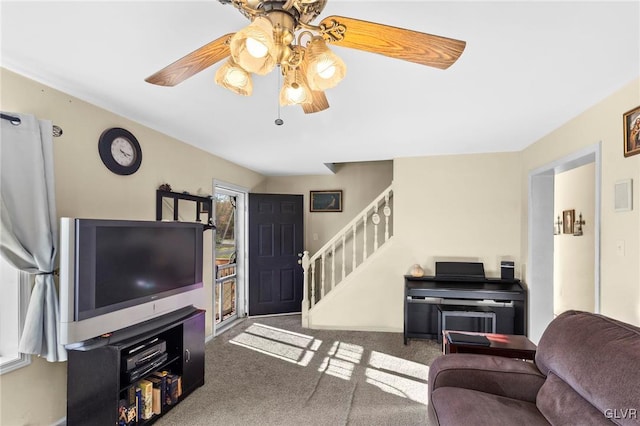 living room featuring dark colored carpet and ceiling fan