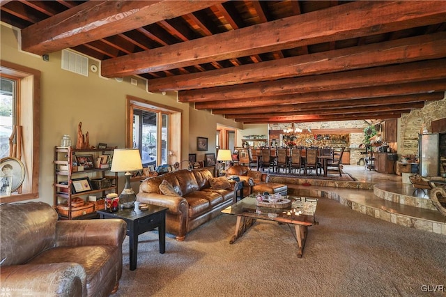 living room featuring beamed ceiling, carpet floors, and plenty of natural light