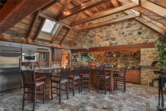 bar with wood ceiling, decorative backsplash, beamed ceiling, a skylight, and stainless steel appliances