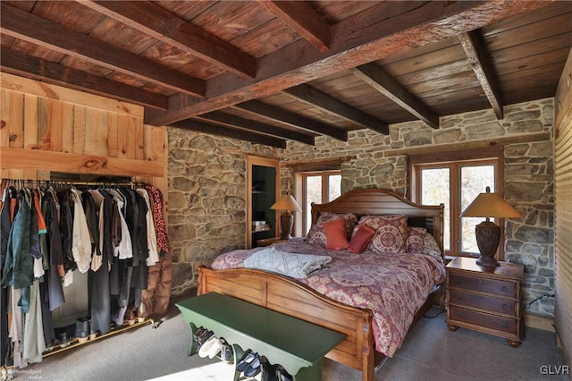 bedroom with beam ceiling, wooden ceiling, and dark colored carpet