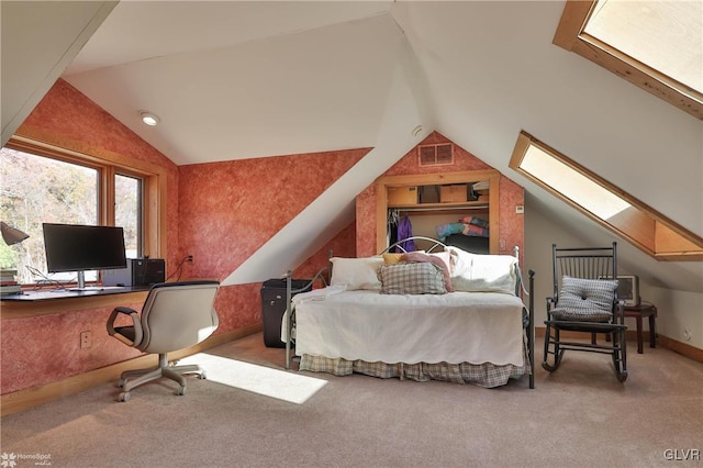 carpeted bedroom featuring vaulted ceiling with skylight