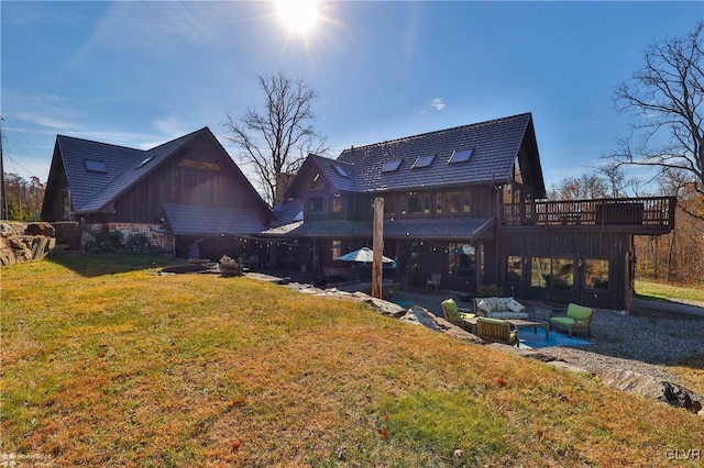 back of property featuring a wooden deck, a patio area, and a yard