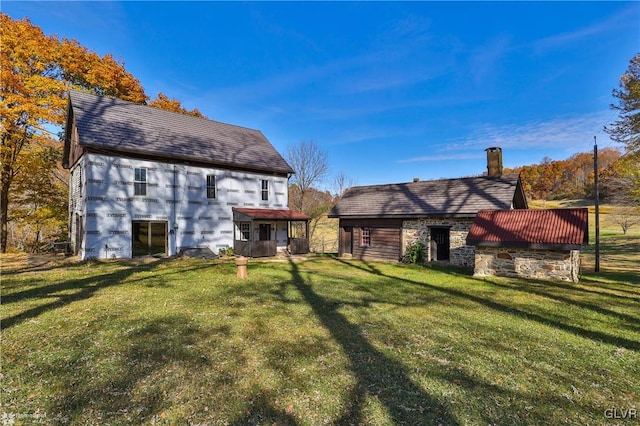 rear view of property featuring a lawn