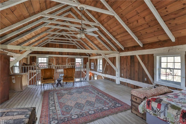 interior space with lofted ceiling with beams, multiple windows, and hardwood / wood-style floors