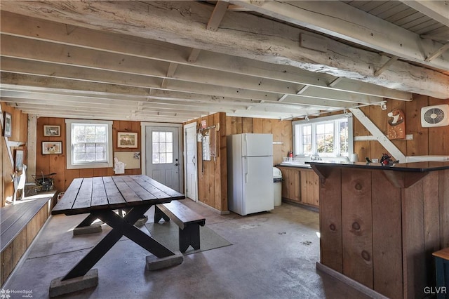 unfurnished dining area with wooden walls and plenty of natural light