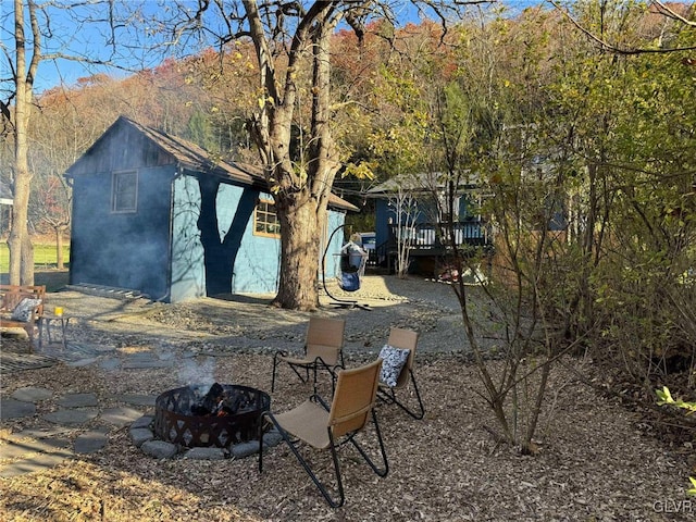 exterior space featuring an outdoor structure, a mountain view, and a fire pit