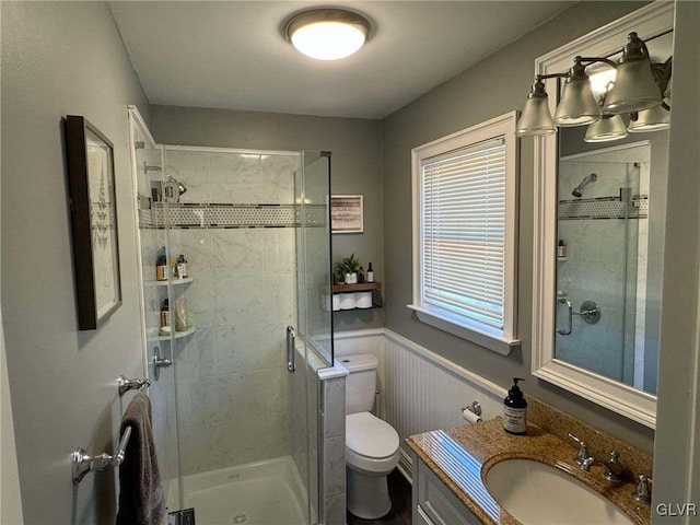 bathroom with toilet, an enclosed shower, wood walls, and vanity