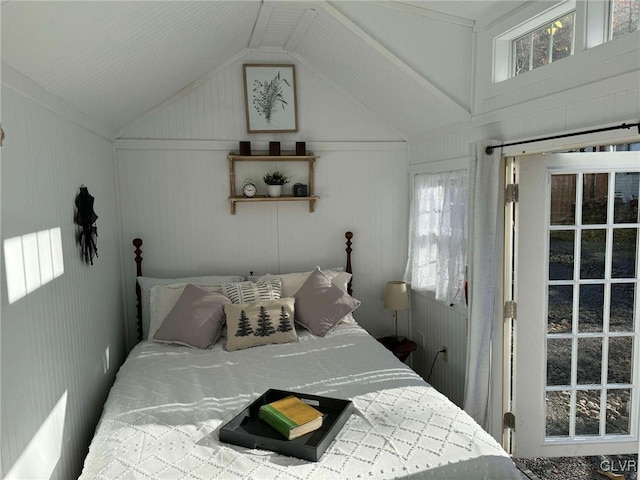 bedroom featuring multiple windows, wooden walls, and lofted ceiling