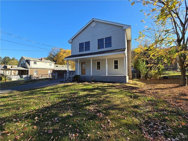 front facade featuring covered porch and a front lawn