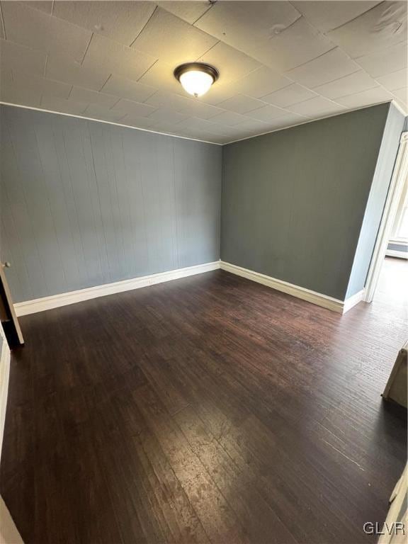 empty room featuring a baseboard radiator and dark hardwood / wood-style flooring