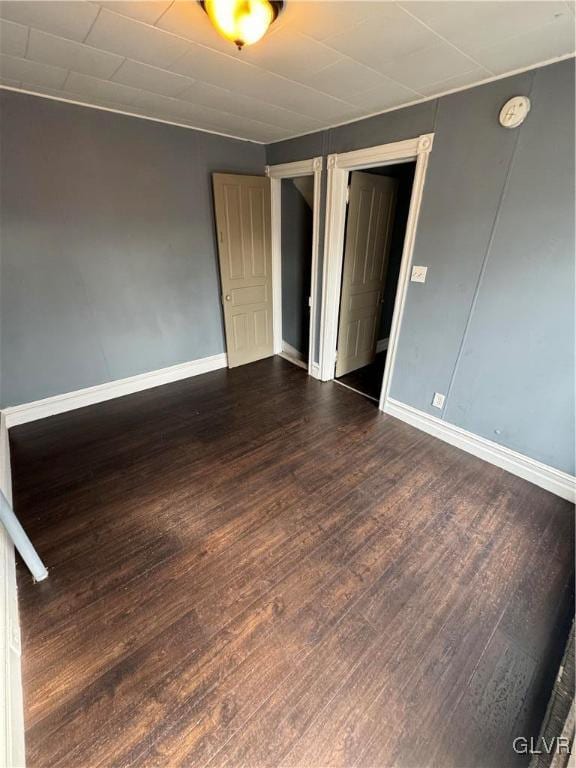 unfurnished room with dark wood-type flooring