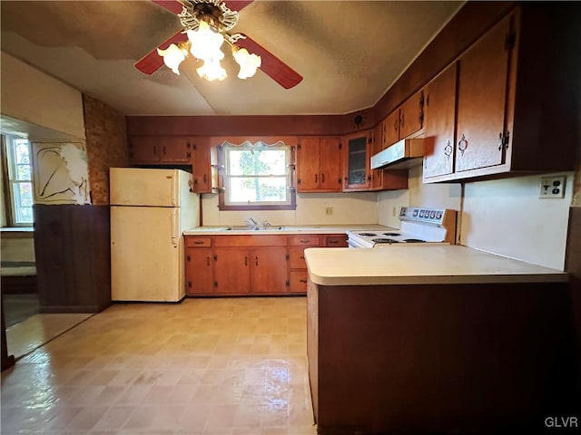 kitchen with sink, kitchen peninsula, white appliances, and ceiling fan