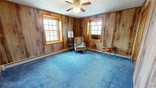 unfurnished room with a healthy amount of sunlight, a baseboard heating unit, and wooden walls