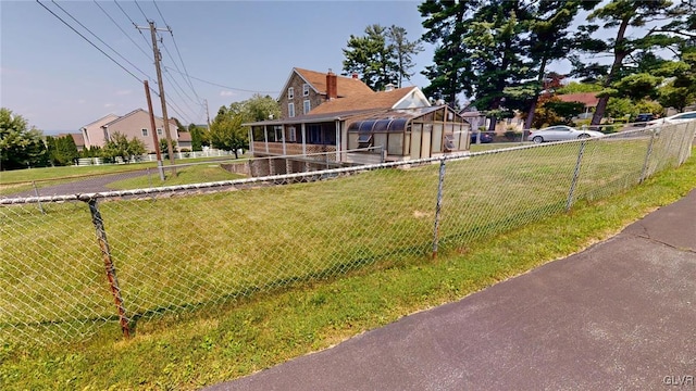 view of front facade with a sunroom and a front lawn