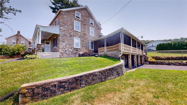 exterior space with a front lawn and a sunroom