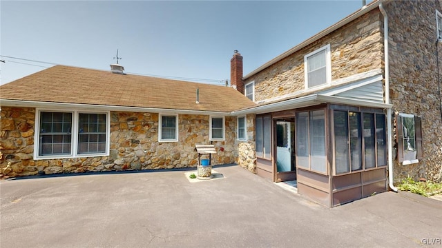 rear view of property featuring a patio and a sunroom