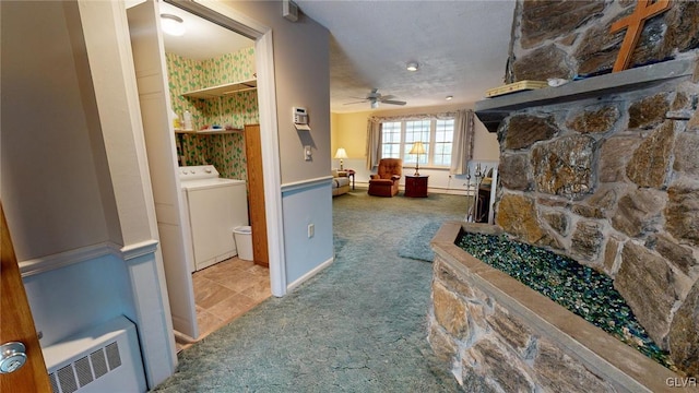 hallway with washer / dryer, a textured ceiling, and carpet floors