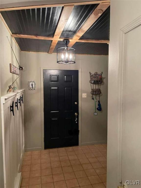 entrance foyer with tile patterned floors, wood ceiling, and beam ceiling