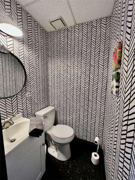 bathroom with vanity, a paneled ceiling, tile walls, and toilet