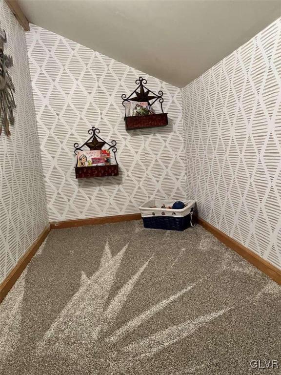 interior space featuring vaulted ceiling and carpet flooring