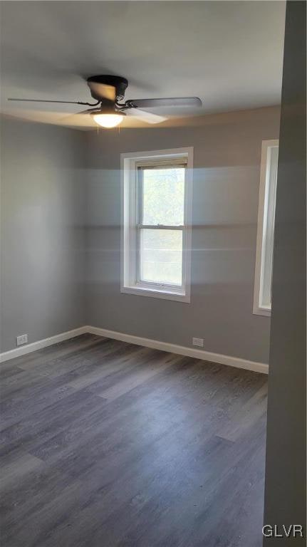 spare room featuring dark wood-type flooring and ceiling fan