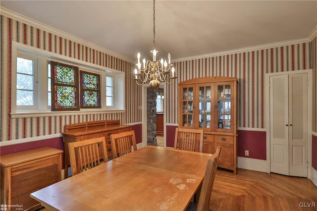 dining area with a wealth of natural light, parquet floors, crown molding, and a notable chandelier