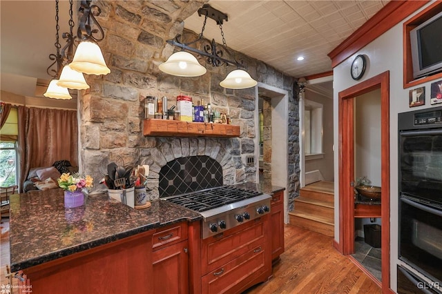 kitchen with pendant lighting, stainless steel gas cooktop, light hardwood / wood-style floors, and black double oven