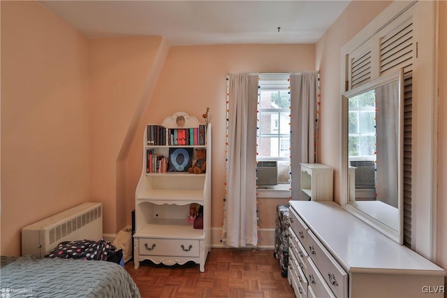 bedroom featuring dark parquet floors, cooling unit, and radiator heating unit