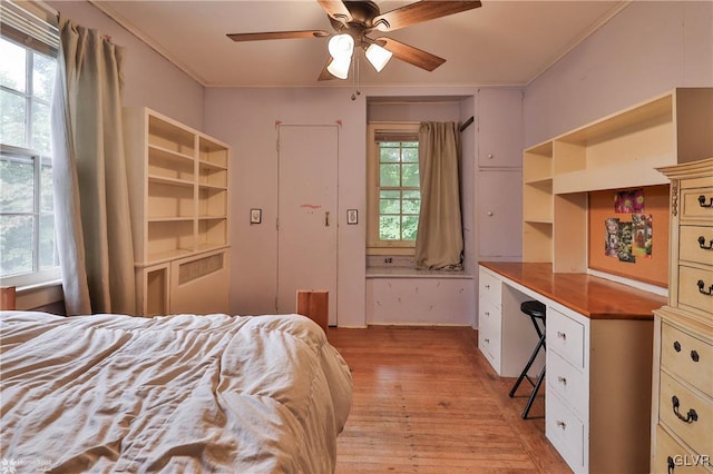 bedroom featuring ornamental molding, light hardwood / wood-style floors, multiple windows, and ceiling fan