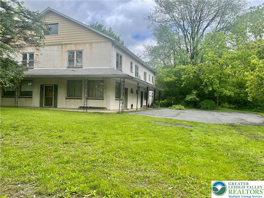 403 N Walnut St, Bath Borough, PA 18014 - back of house with stucco siding, a yard, and covered porch