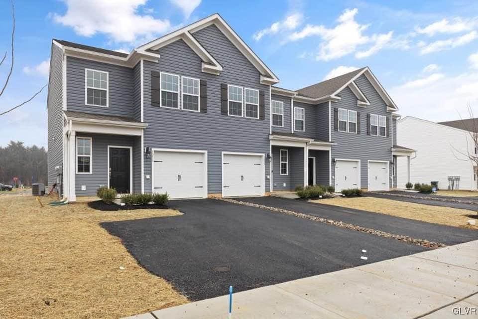 view of front of property with a garage and central AC