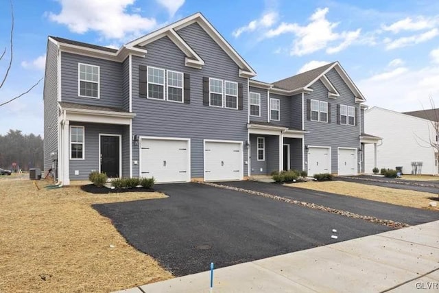 view of front of property with a garage and central AC