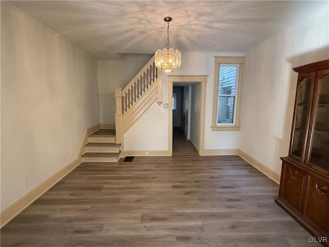 interior space featuring ornamental molding, a notable chandelier, and dark hardwood / wood-style floors